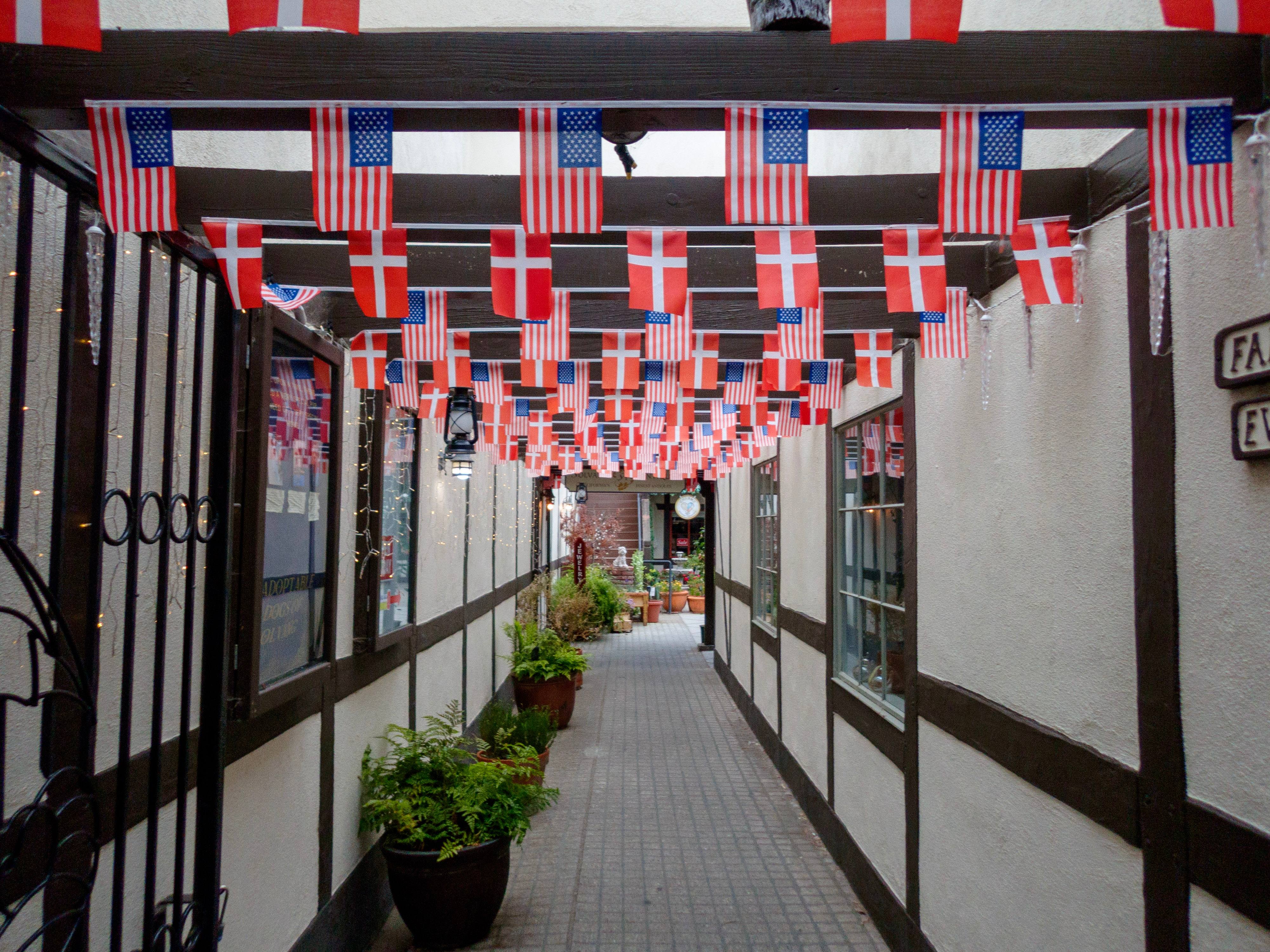 Alleyway in Solvang with Danish and American flags hanging from the rafters